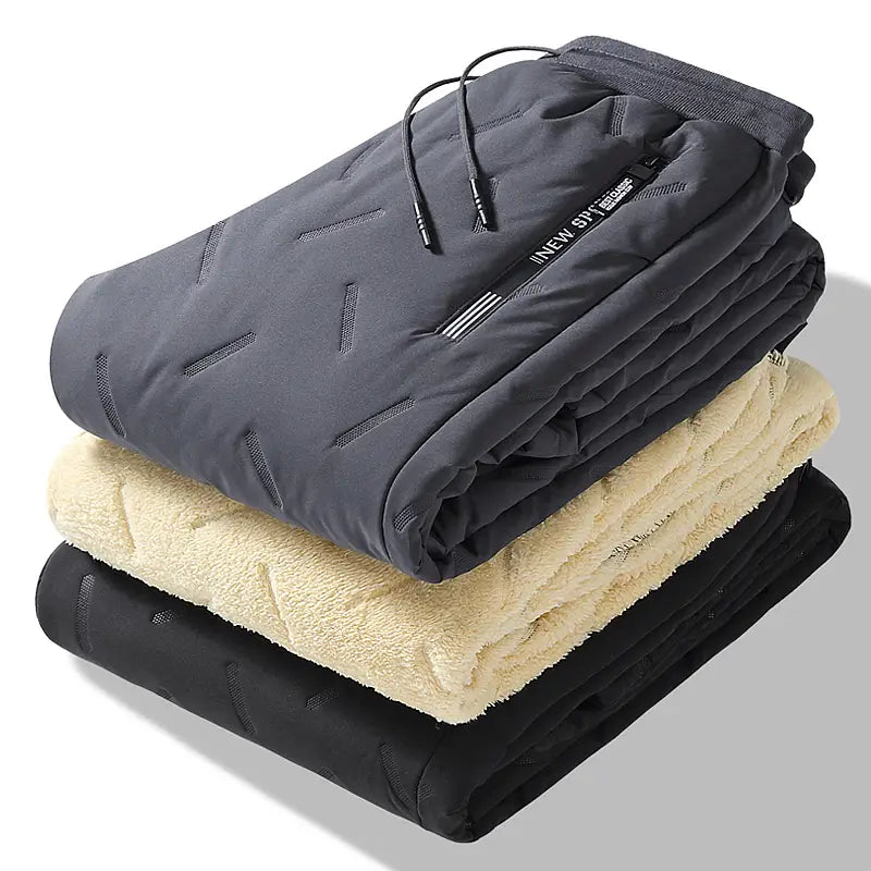 Dark gray fleece lined thermal sweatpants with a quilted outer shell and geometric stitching details designed for waterproof winter wear.