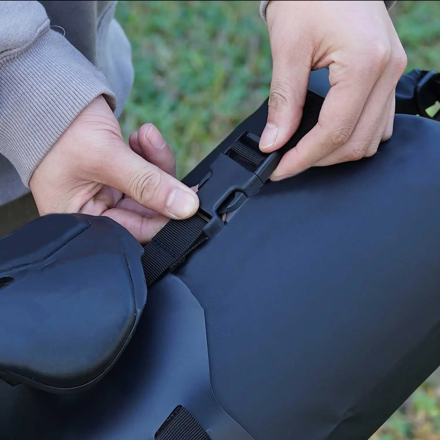 Black waterproof bike saddle bag stabilizer bracket carrier shown from the back with adjustable strap and buckle for secure attachment.