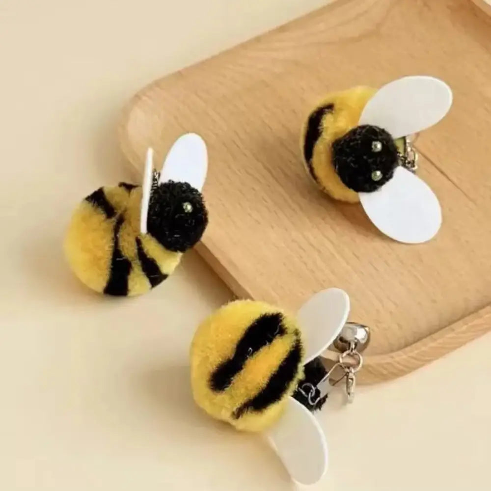 黄と黒の毛むくじゃらのハチのキーホルダーで、白いプラスチック製の翼を備え、ぬいぐるみのようなハチのインタラクティブ猫おびき寄せ玩具のタイプとして設計されたもの。