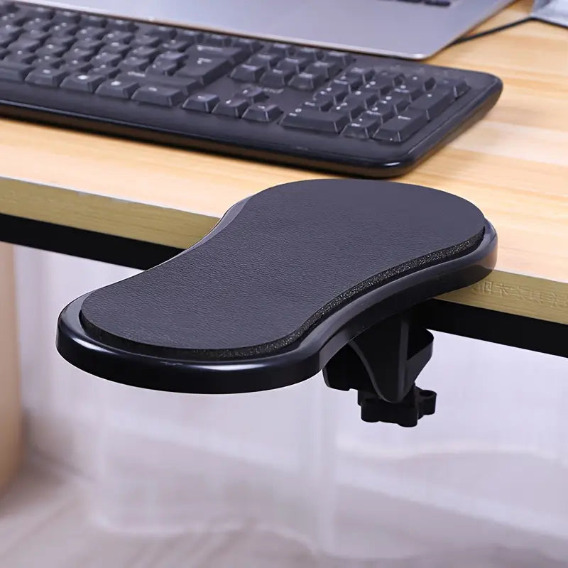 Black ergonomic desk armrest extender with a textured surface and adjustable clamp for improved comfort and support during computer use.