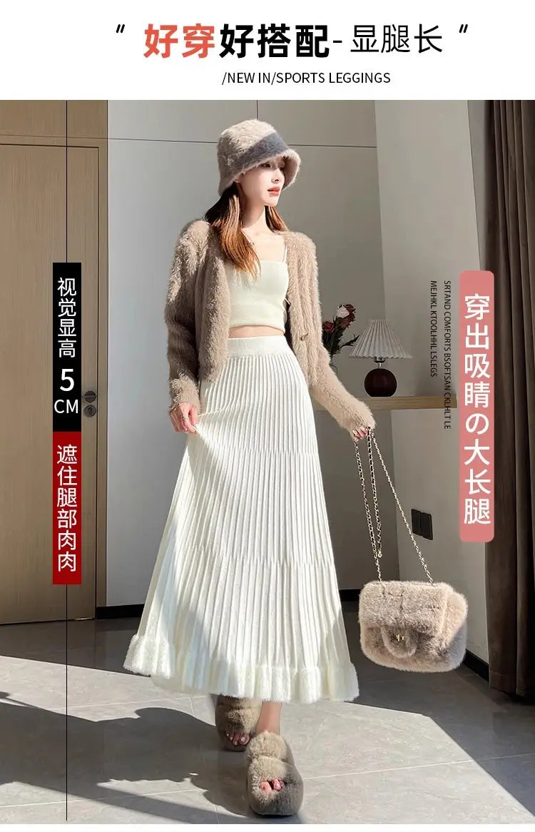 Jupe mi-longue en maille blanche, avec taille haute et design parapluie à plis, présentée de face.