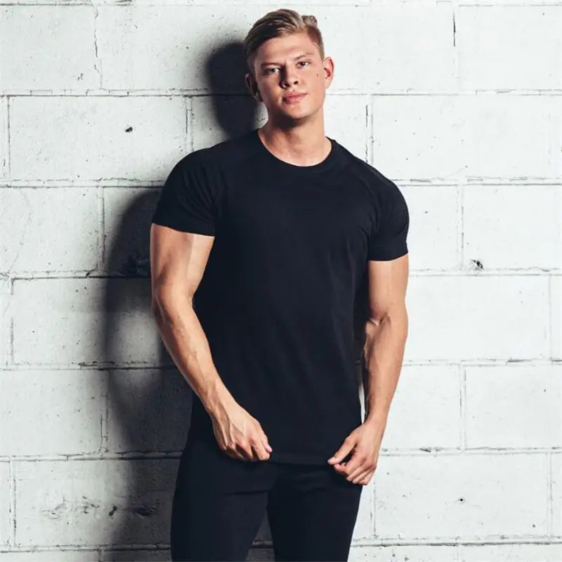 T-shirt de sport en coton ajusté slim fit pour homme, noir, à manches courtes, encolure ras du cou, présenté de face.