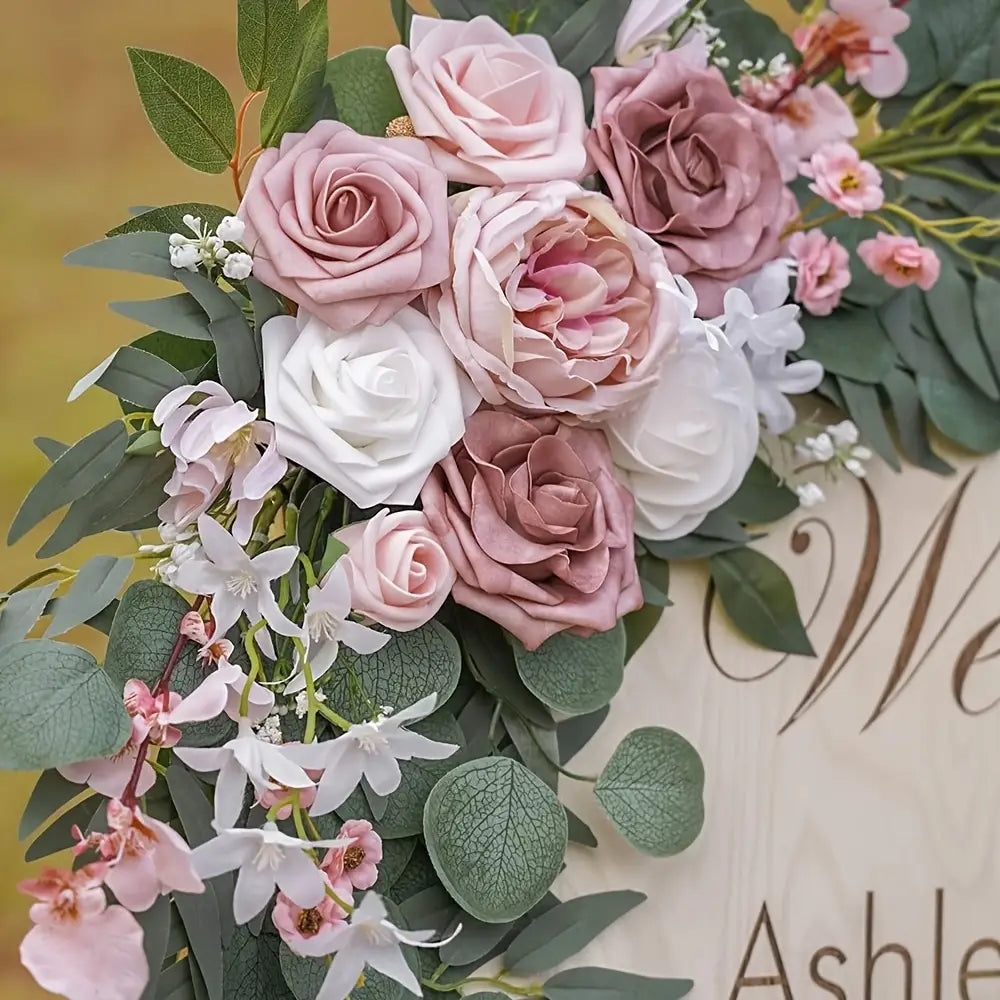 Juego de flores para arco de boda con rosas artificiales, que incluye un arreglo delicado de pétalos de tela en tonos rosa suave, blanco y malva tenue, con hojas de eucalipto verdes.