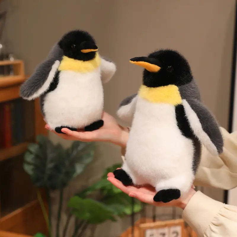 Soft plush penguin stuffed animal soft toy pair with black white and yellow accents made of plush material.