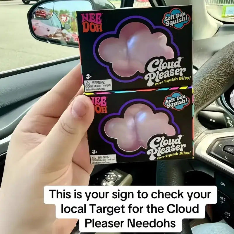front view of pink cloud-shaped Needoh Cloud Pleaser slow rising squishy toys in black and purple packaging