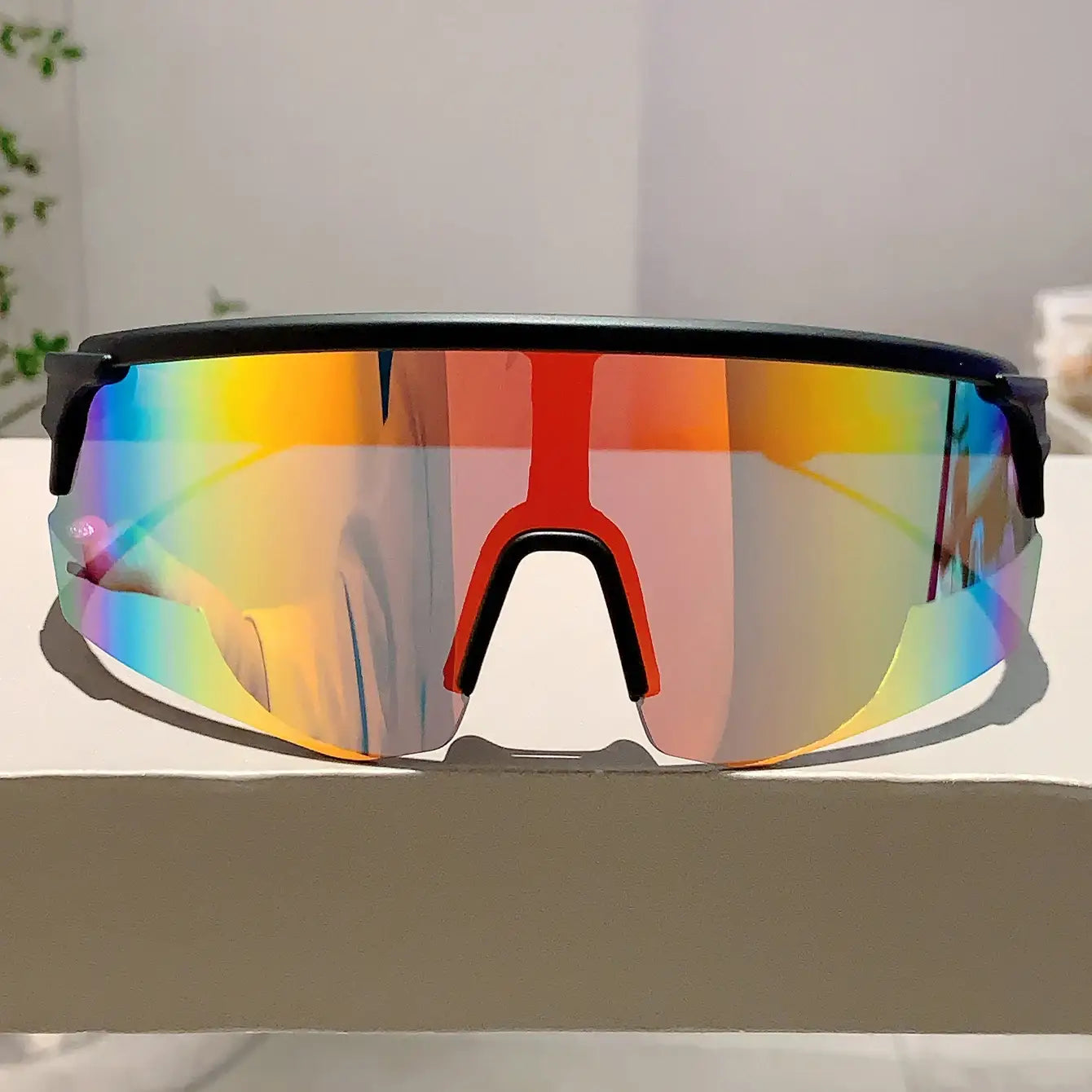 Lunettes de soleil de sport surdimensionnées à monture noire, avec un large verre incurvé doté d’un revêtement réfléchissant vibrant arc-en-ciel, idéales pour le cyclisme.
