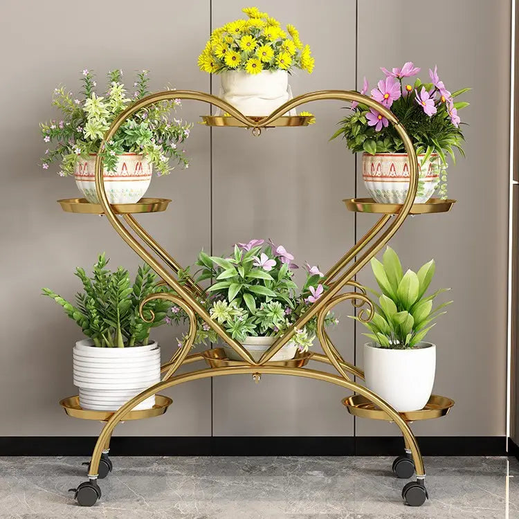 Blumenständer aus goldfarbenem Metall in Herzform mit vier Ebenen und schwarzen Lenkrollen zur Präsentation von Blumentöpfen
