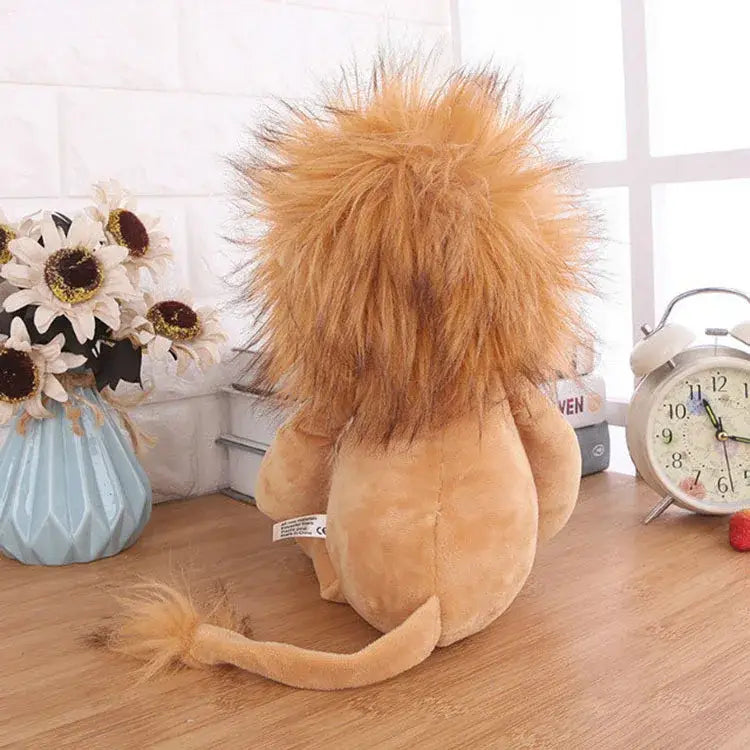 a plush lion toy with a fluffy golden mane and tan body sitting on a wooden surface from the lion elephant tiger plush stuffed animal toy collection