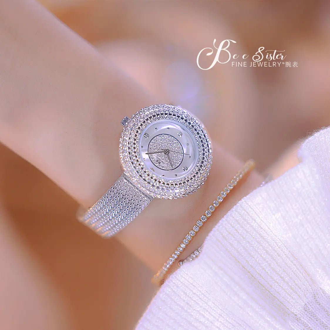 A sparkling silver diamond-encrusted luxury waterproof women watch with a mesh band worn on a wrist.