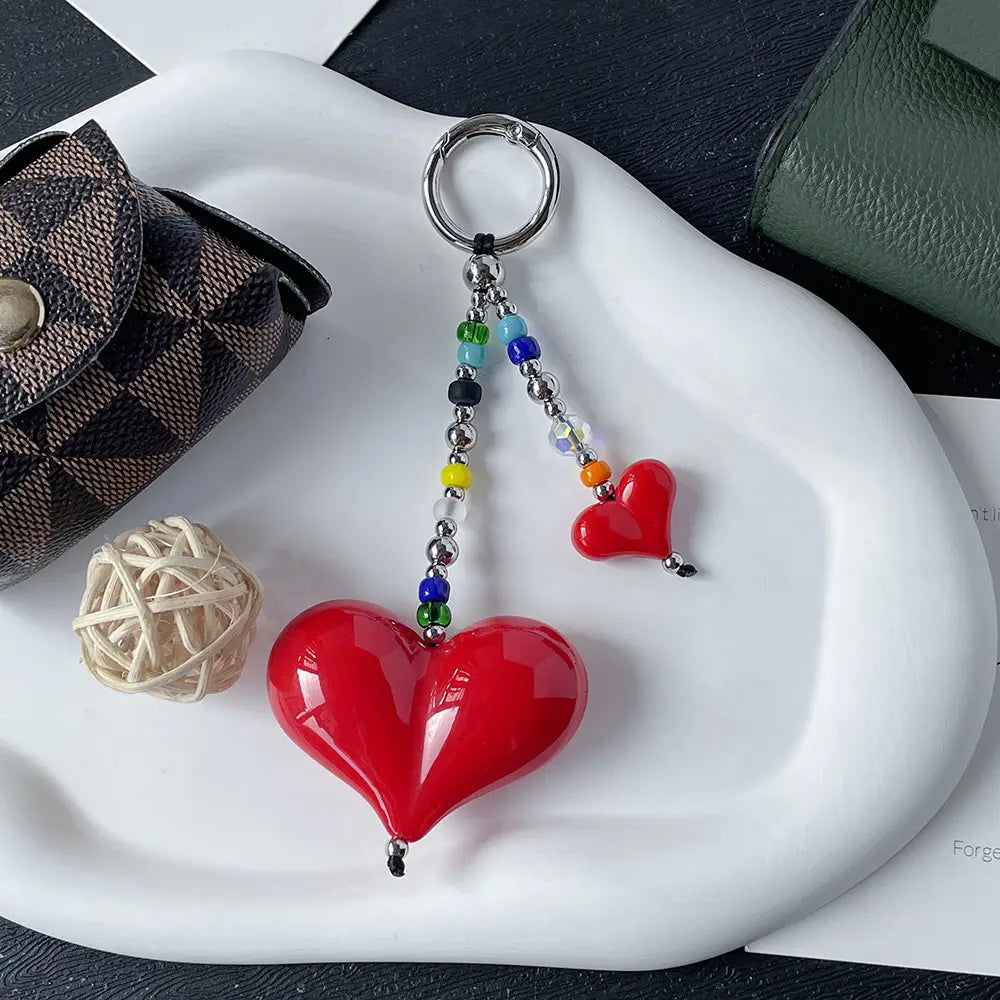 Porte-clés en forme de cœur rouge éclatant, finition vitrée brillante et chaîne à perles colorées, utilisé comme pendentif pour sac à perles.