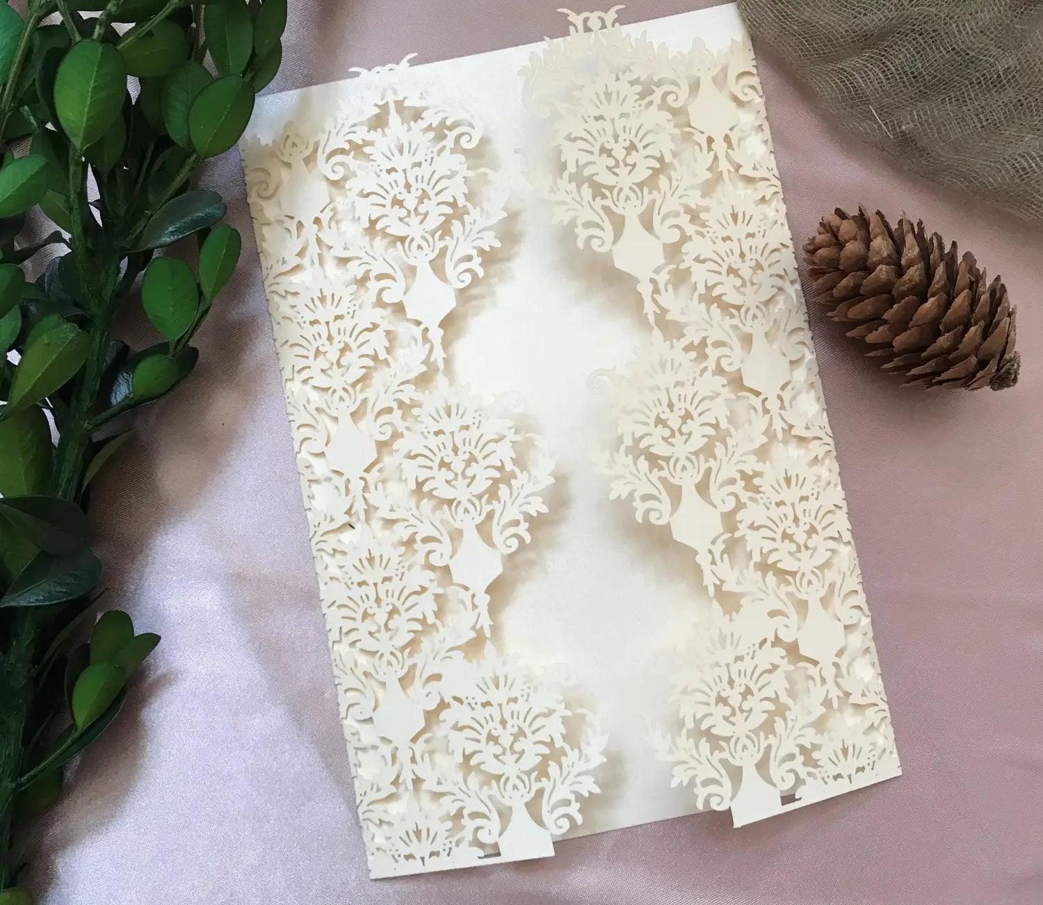 Elegant ivory laser cut wedding invitation card featuring intricate damask floral patterns and delicate lace-like detailing in a 10 pack set.