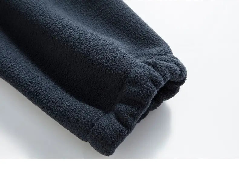 Puño de pantalón de forro polar gris oscuro con textura esponjosa suave y dobladillo elástico acanalado, diseñado para ropa de abrigo y exterior cálida de chaqueta de invierno de forro polar para hombre.