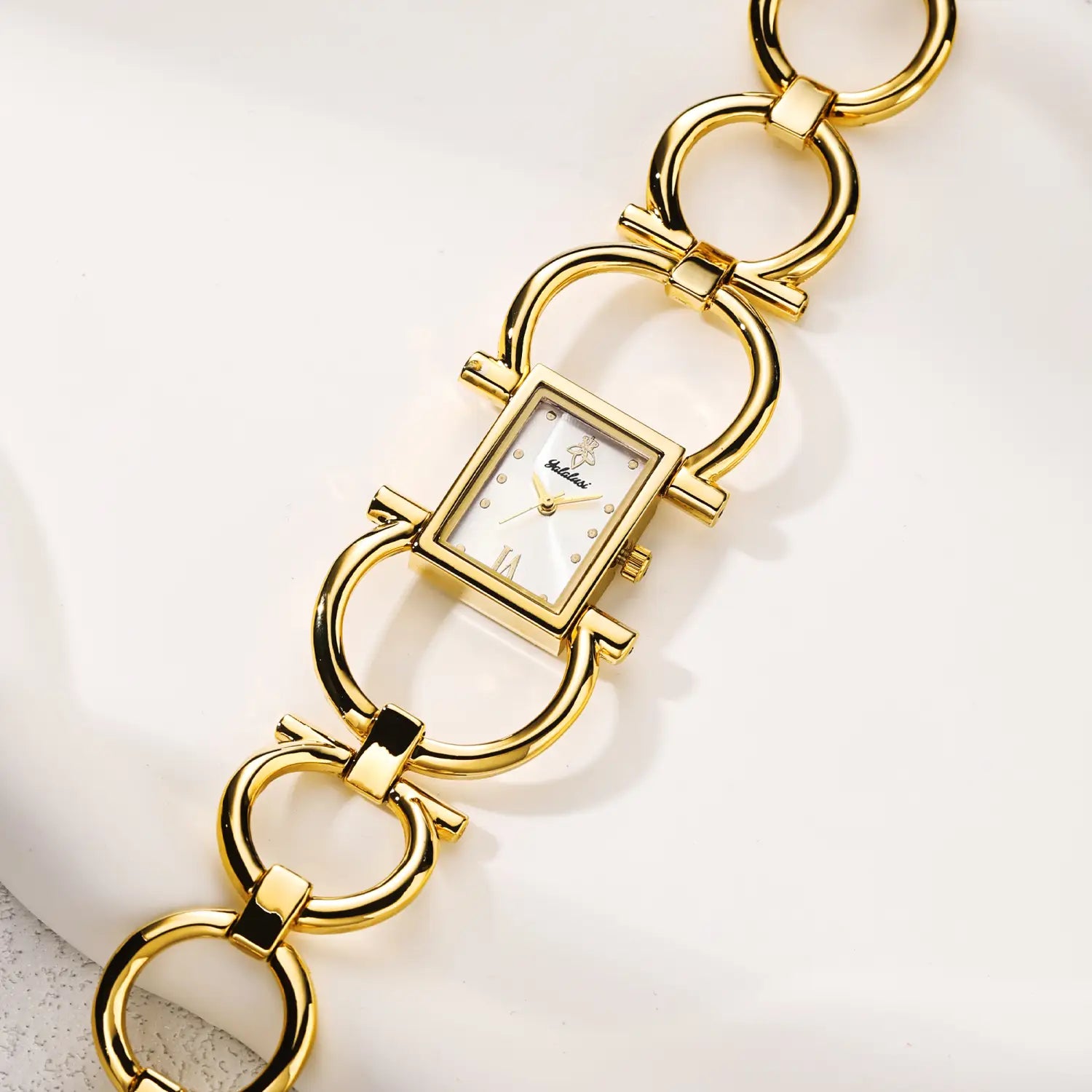 Gold luxury quartz women watch bracelet with a gold-toned rectangular case, white dial, and roman numeral hour markers.