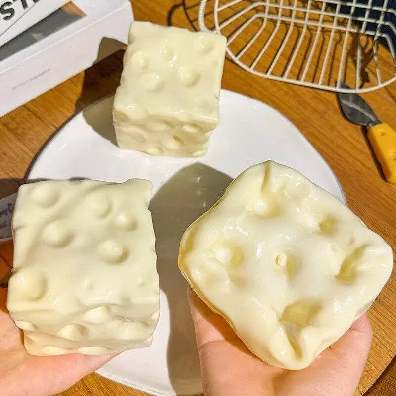 Cream-colored cheese block stress relief squeeze toy soap bars with a textured surface mimicking holes for stress relief.