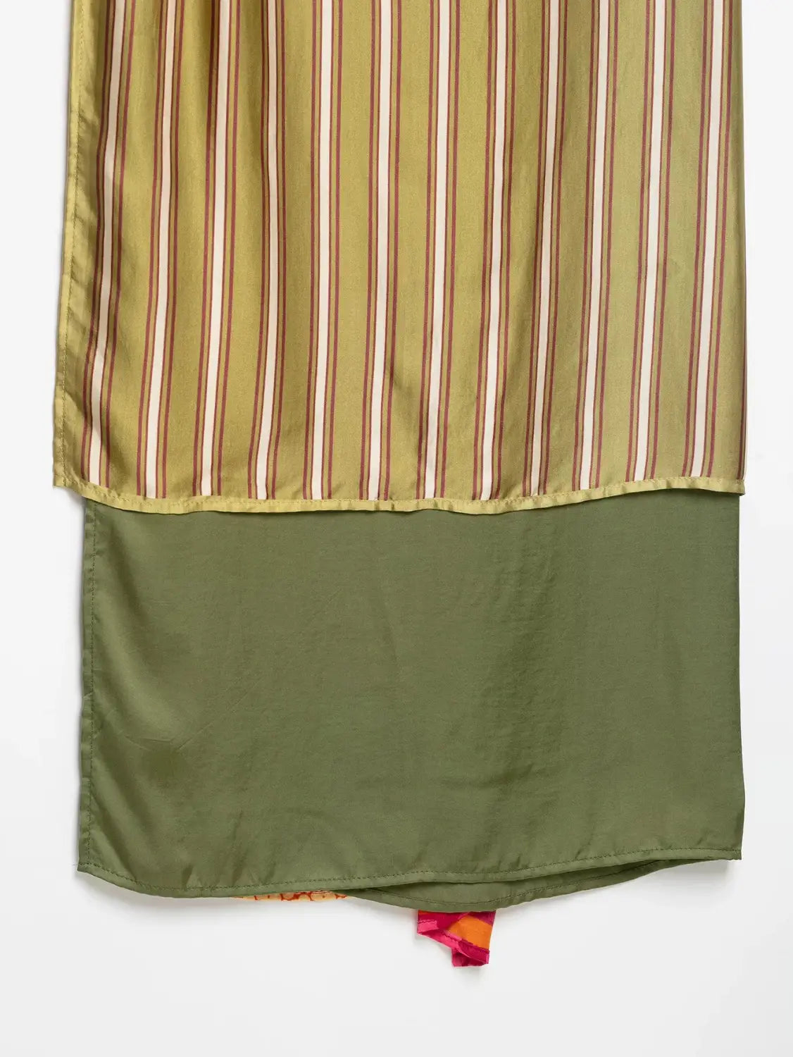 A flowing olive green and beige striped silk scarf with a solid olive green hem paired with a floral print two piece midi skirt set.