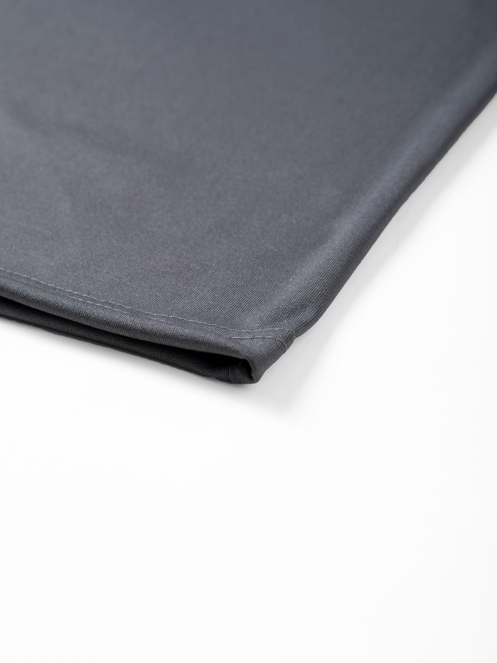 Dark gray fabric sheet with a smooth slightly textured surface and neatly stitched edges for mens raglan long sleeve casual t-shirt.