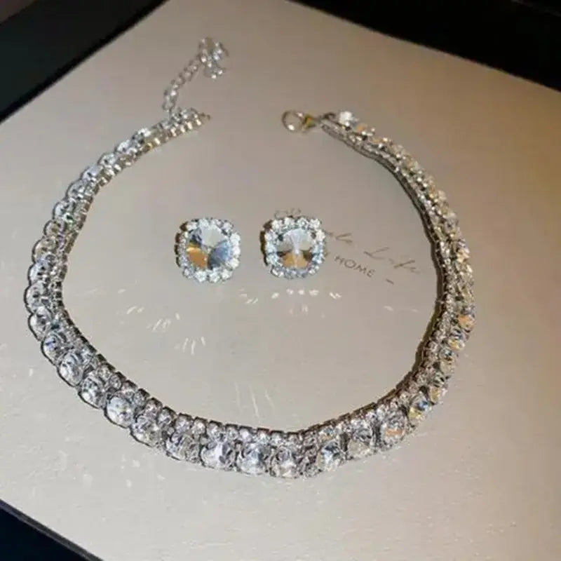 A sparkling silver crystal necklace and earring set adorned with clear rhinestones in a dazzling layered design suitable for pink ab wedding jewelry.