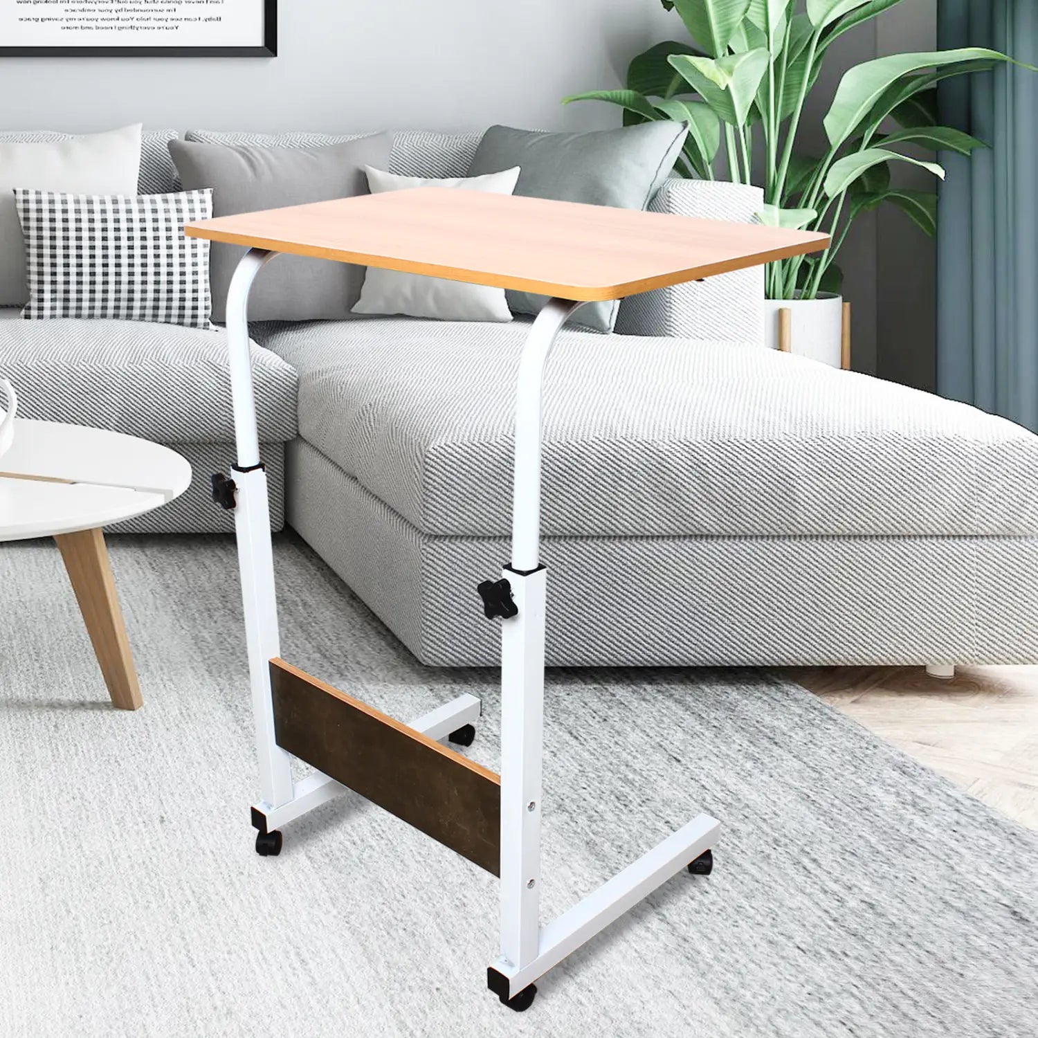 Tablette roulante pour ordinateur portable à hauteur réglable en blanc, avec plateau à finition chêne clair et roues pivotantes noires pour plus de mobilité.
