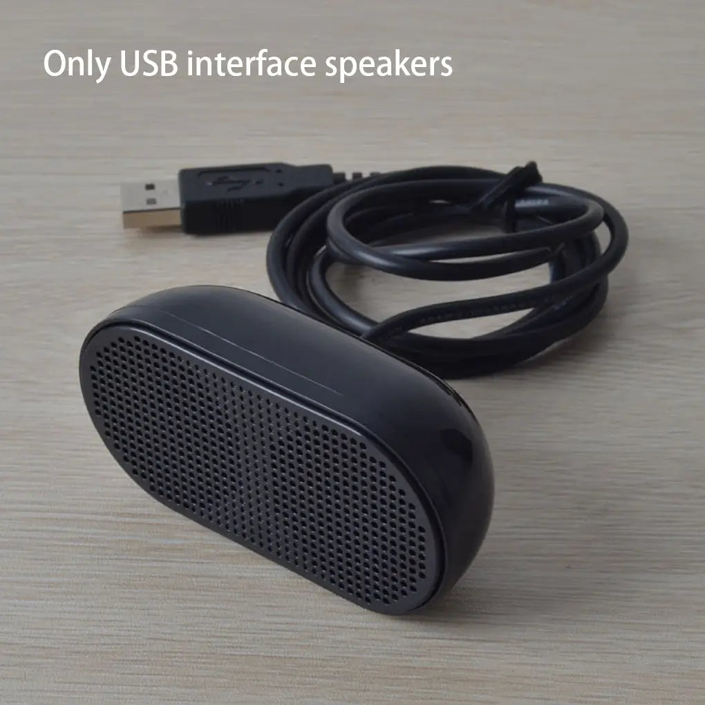 Schwarzer, oval geformter USB-Mini-Lautsprecher für Laptops mit perforiertem Frontgitter und passendem schwarzem Kabel für die Nutzung als tragbare Computer-Soundbar.