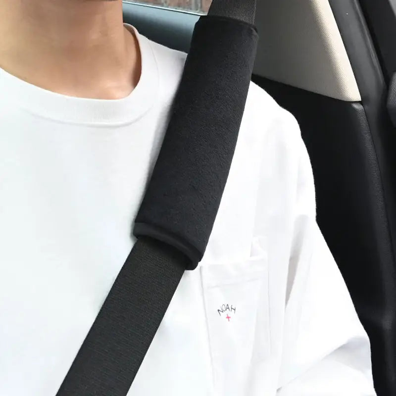 black fabric plush seat belt cover showing the back side designed as a car shoulder pad for comfort and protection.