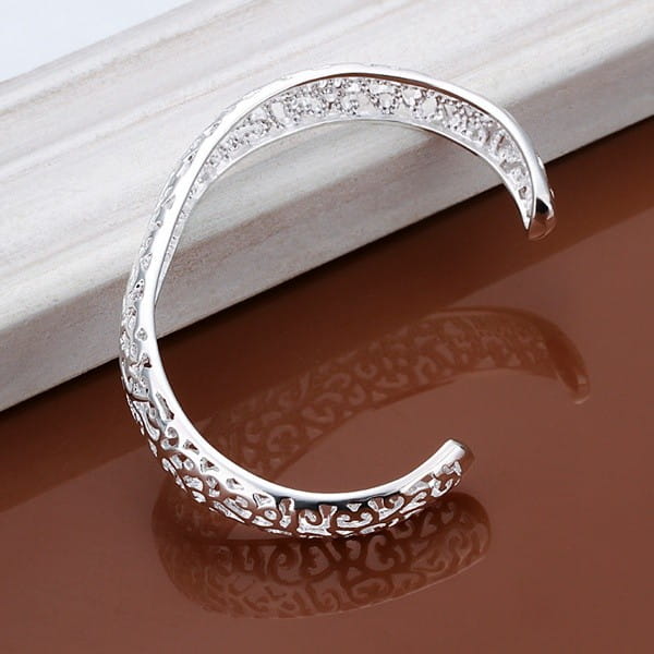Sterling silver filigree cuff bracelet featuring an open design with intricate patterns and embedded clear crystals along the top edge.