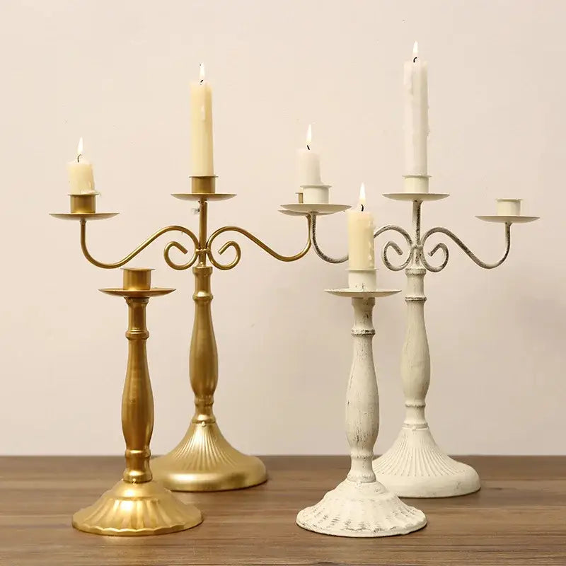 porte-bougies en or et en métal blanc avec des bras finement ouvragés et des volutes, tenant des bougies allumées pour des décorations de table, mariage d’hôtel moderne européen et décoration, pour un mariage d’hôtel.