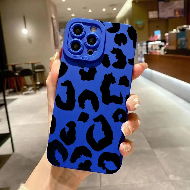 Back side of a vibrant blue leopard-print matte black iPhone case with a matching camera lens cover designed for camera protection.