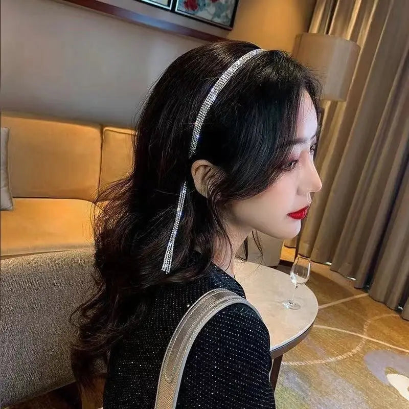 A sparkling silver crystal rhinestone tassel headband for women featuring a dangling crystal tassel.