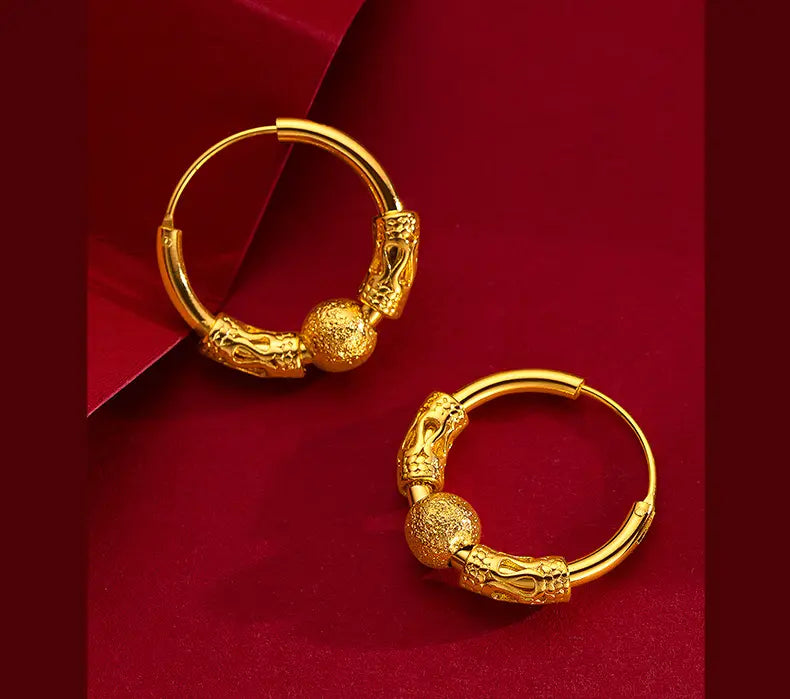 Ohrringe mit Gold-Drachenring mit kunstvollen Drachenkopfmotiven und strukturierten kugelförmigen Akzenten als feines Schmuckgeschenk in Gold.