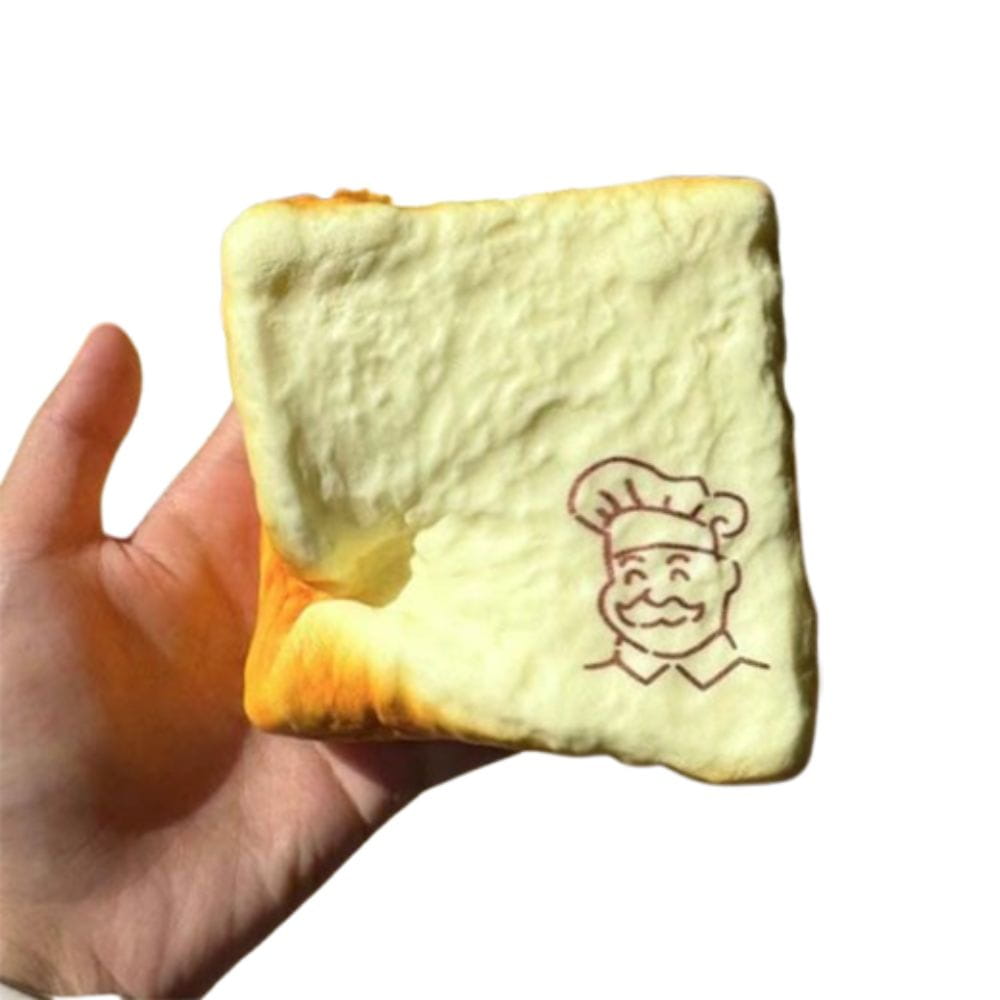 a soft pale yellow squishy toy shaped like a bread slice with a golden-brown crust and a simple chef illustration on the front designed as a sensory fidget toy for universal age range.