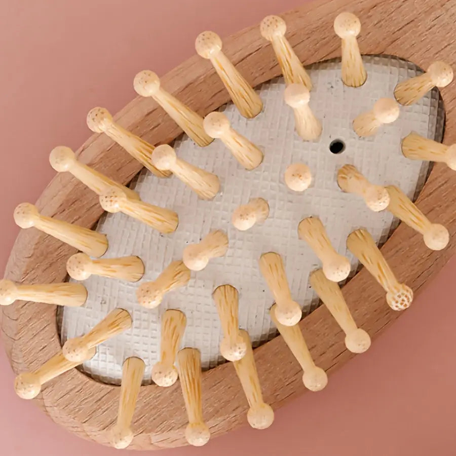 baby wooden grooming set featuring an oval-shaped wooden brush with light-colored wooden bristles and a textured white base for gentle baby care.