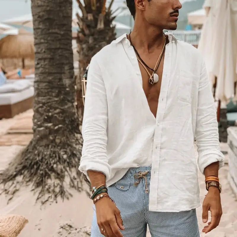 Un hombre que lleva una camisa blanca de manga larga tipo botón con puños arremangados y cuello abierto, mostrando una camisa casual de lino color verde oliva para hombre.