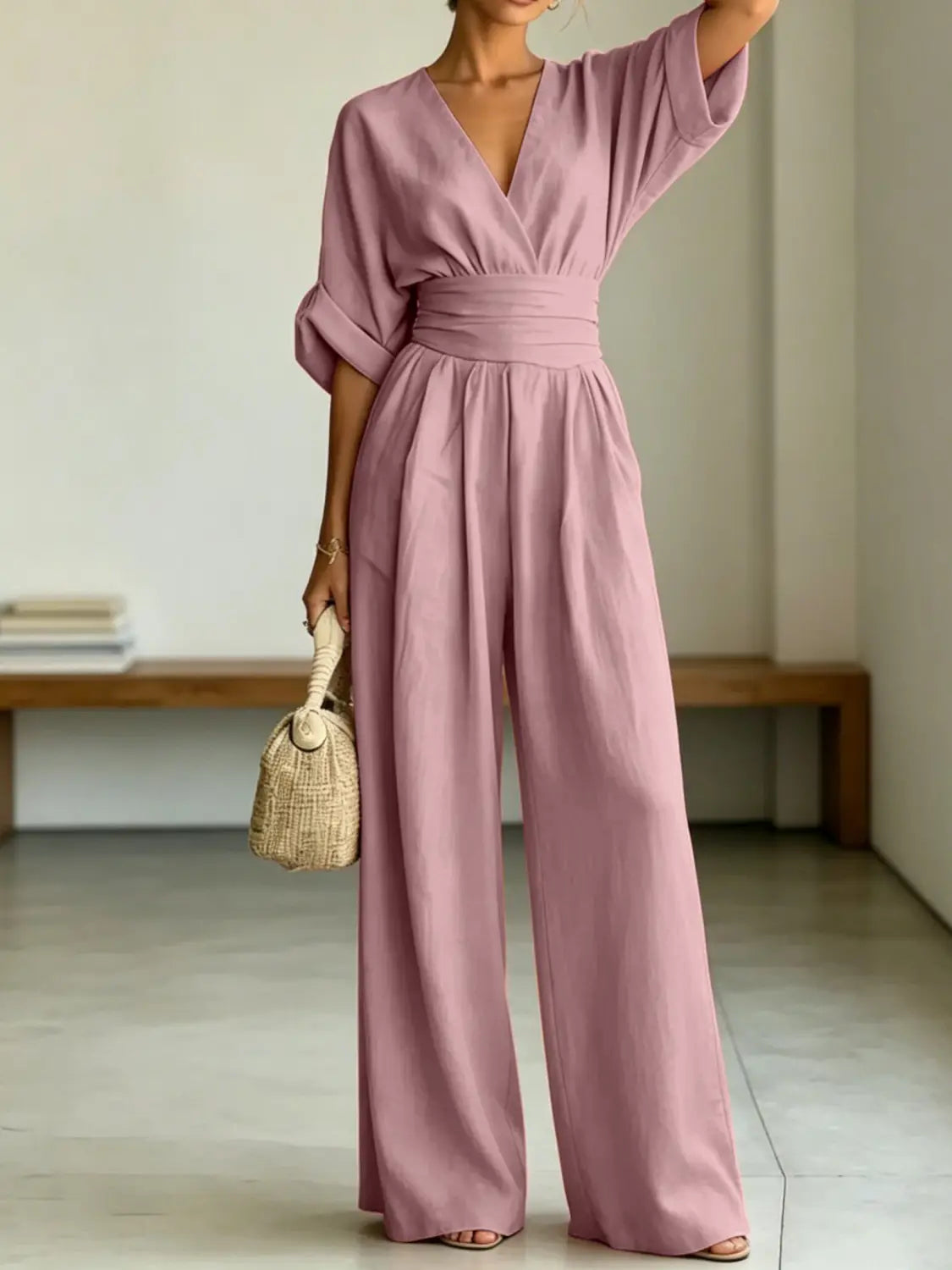 A soft lavender-colored flowing wide-leg jumpsuit with a v-neckline and cinched waistband made from lightweight fabric.
