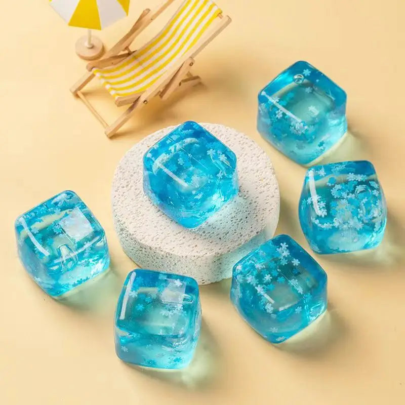 clear blue squishy snowflake ice cubes with embedded white snowflake patterns designed as slow rising sensory fidget toys.