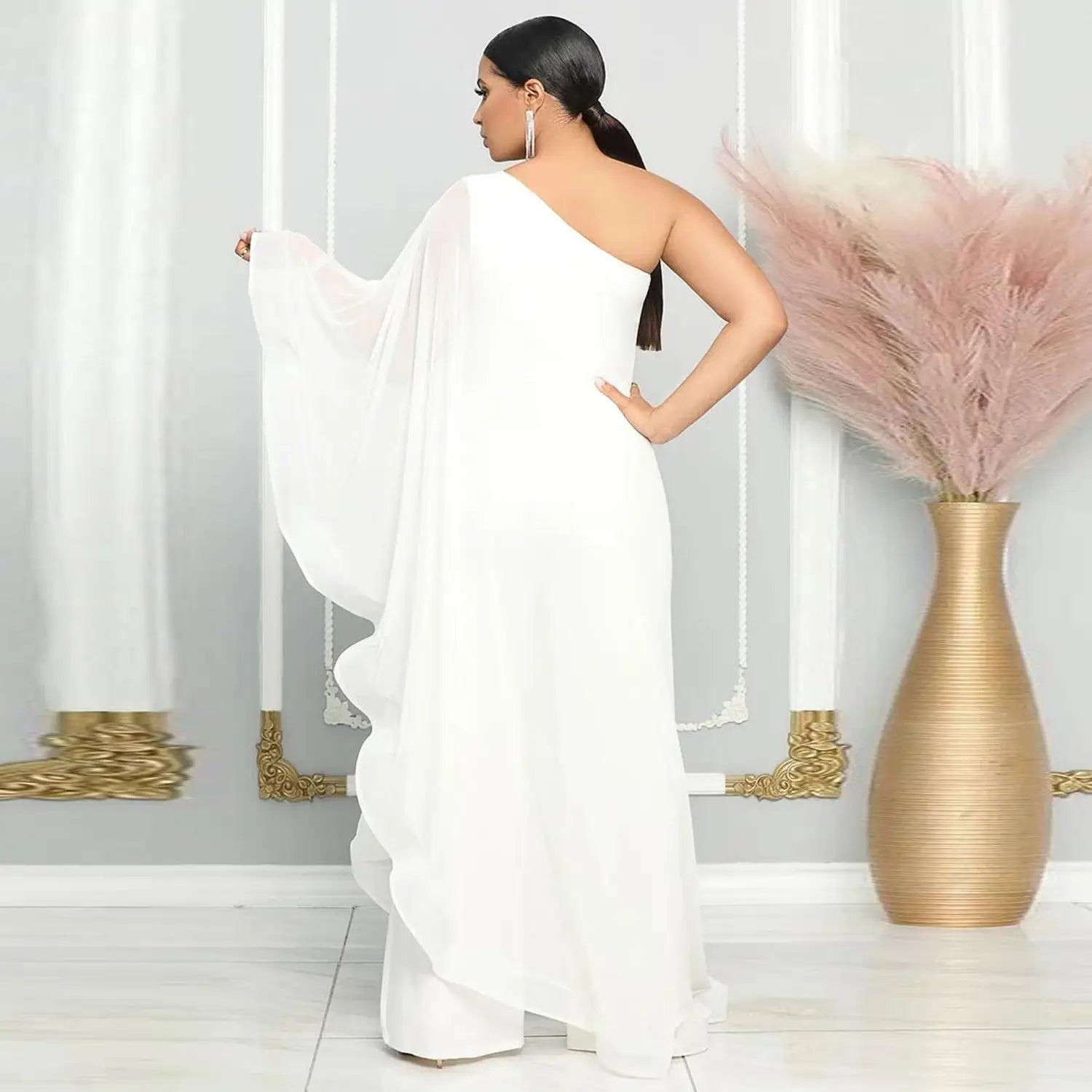Ein fließender weißer Chiffon-Jumpsuit mit einer Schulter und gerafften Glockenärmeln für einen eleganten Look.