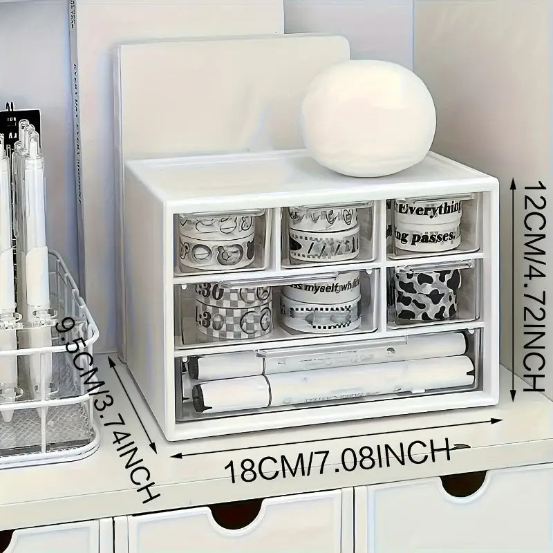 Organisateur de bureau en plastique blanc avec tiroirs transparents contenant des rouleaux de ruban washi et des marqueurs, pour un rangement efficace des fournitures artistiques.