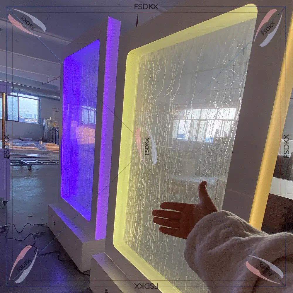 現代的な壁掛け型の、質感のある半透明パネルを備え、発光するイエローのLEDフレームで縁取られた、照明付きウェディング用ウォーターファウンテン背景看板。