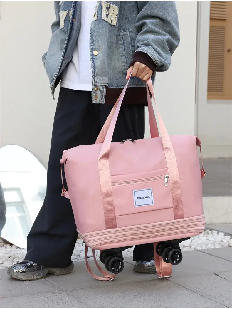 Un sac duffel roulant rose à grande capacité, avec des poignées et des roues assorties, idéal pour voyager.