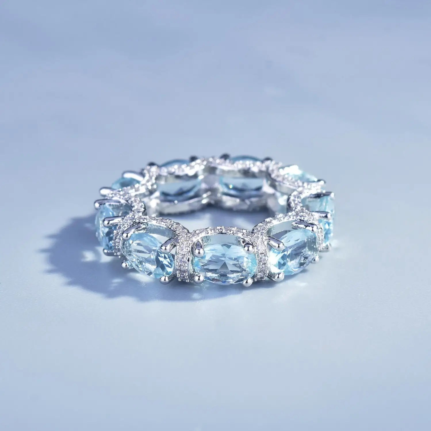 Elegant oval-cut aquamarine crystal bridal ring set in a platinum band with sparkling diamond accents.