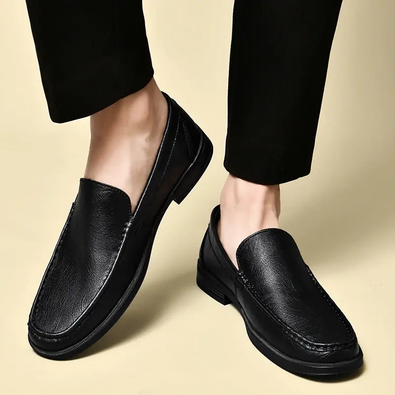 Men genuine leather slip-on dress loafers in black with a smooth slightly textured finish and subtle stitching along the seams.