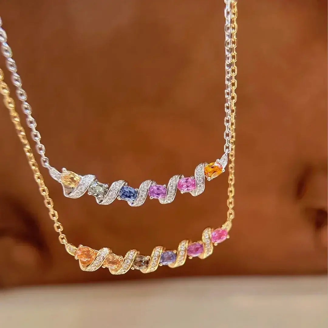 Un délicat collier à double rangée en argent, avec un motif tourbillonnant comportant des pierres précieuses colorées serties dans un métal ton argent et or.