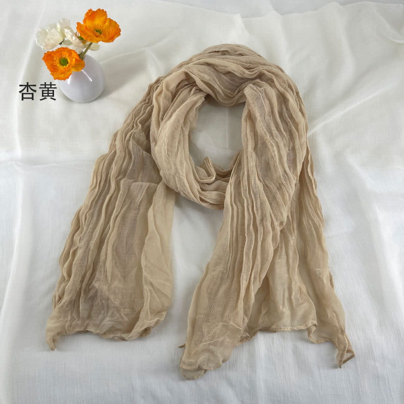 Écharpe en coton et lin plissé beige doux, avec une texture légèrement froissée et légère et des plis verticaux discrets.