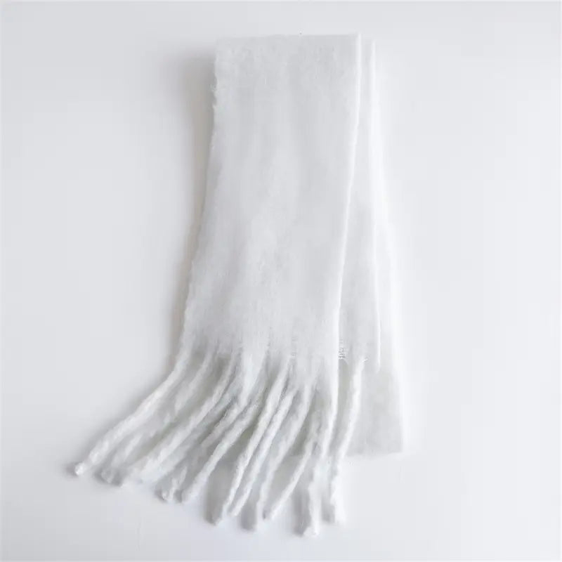 Ein weicher weißer Strick-Schal für Damen mit Cashmere-ähnlichem Gefühl für den Winter mit strukturierter Weboptik und filigranen Fransen-Details.