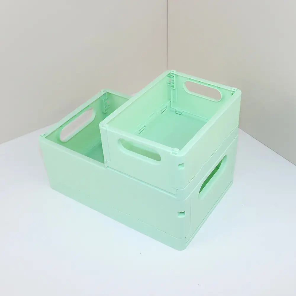 ein mintgrünes faltbares Kunststoff-Aufbewahrungsboxen-Körbchen mit integrierten Griffen und stapelbarem Design, ideal für die Organisation am Desktop