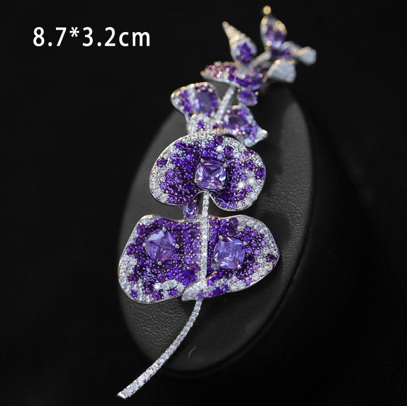 Broche de mariposa de zirconio en forma de orquídea lavanda brillante, adornado con gemas violetas y claras engastadas en metal con acabado en tono de plata.