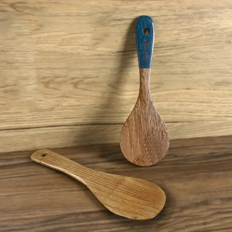 Wooden cooking utensil set featuring a wooden rice paddle with a blue painted handle and natural wood finish safe for nonstick cookware.