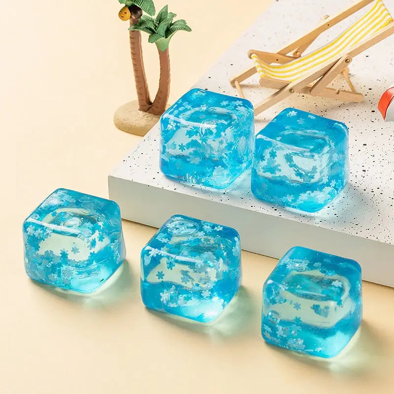 cube sphérique translucide bleu en gel à faible rebond, visqueux et lent, avec des motifs floraux blancs, vu de face