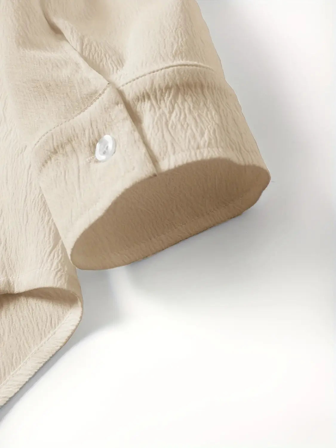 Beige Baumwollhemdmanschette mit einem einzelnen klaren Knopf aus dem Herren-Leinen-Zweiteiler für den Sommer.