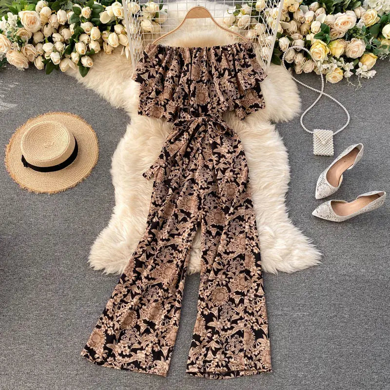 Enterizo de pierna ancha con estampado floral marrón y beige, con escote tipo bardot, mangas con volante y detalle de cintura atada.