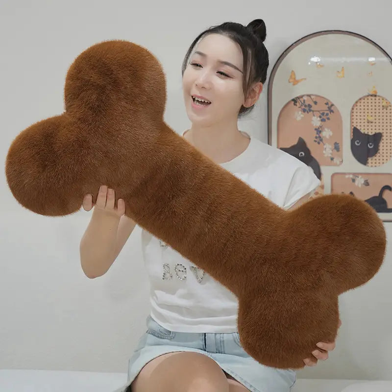 a plush brown faux fur bone shape plush pillow designed as a soft nap cushion